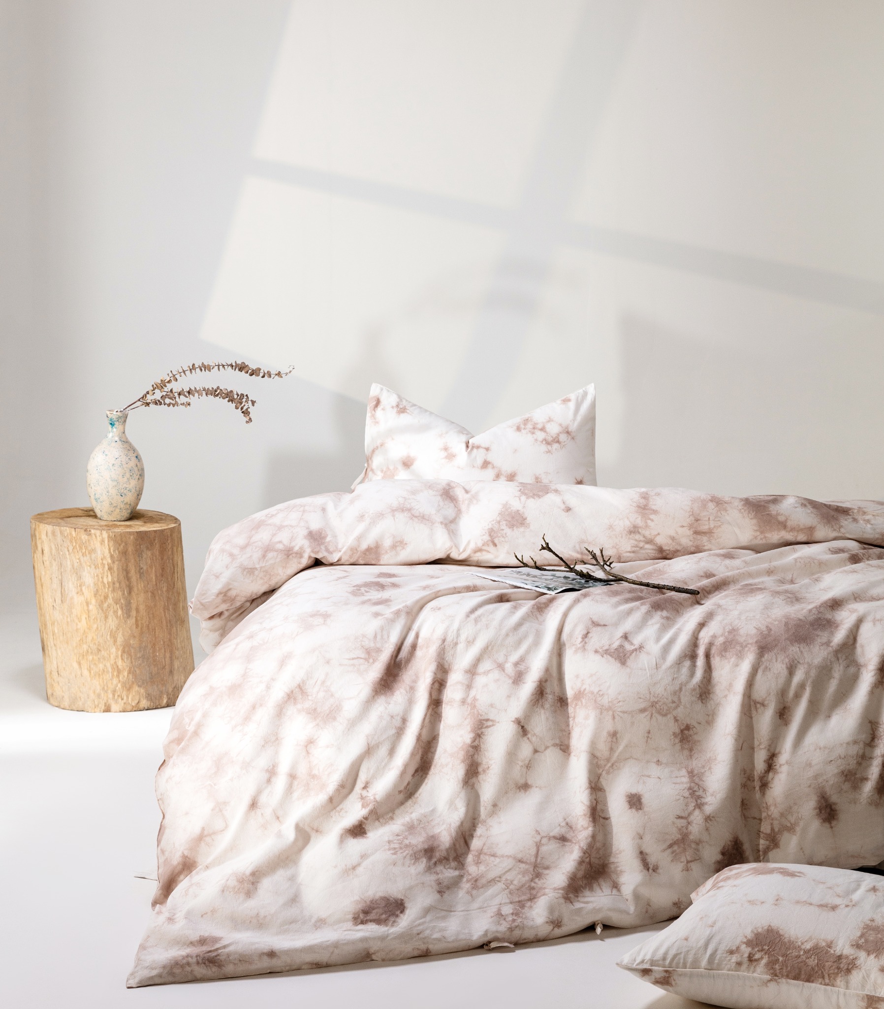Walnut husk plant dyed linen-cotton bedding with pale coffee botanical marks